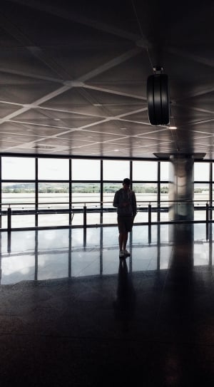 silhouette of man standing inside airport thumbnail