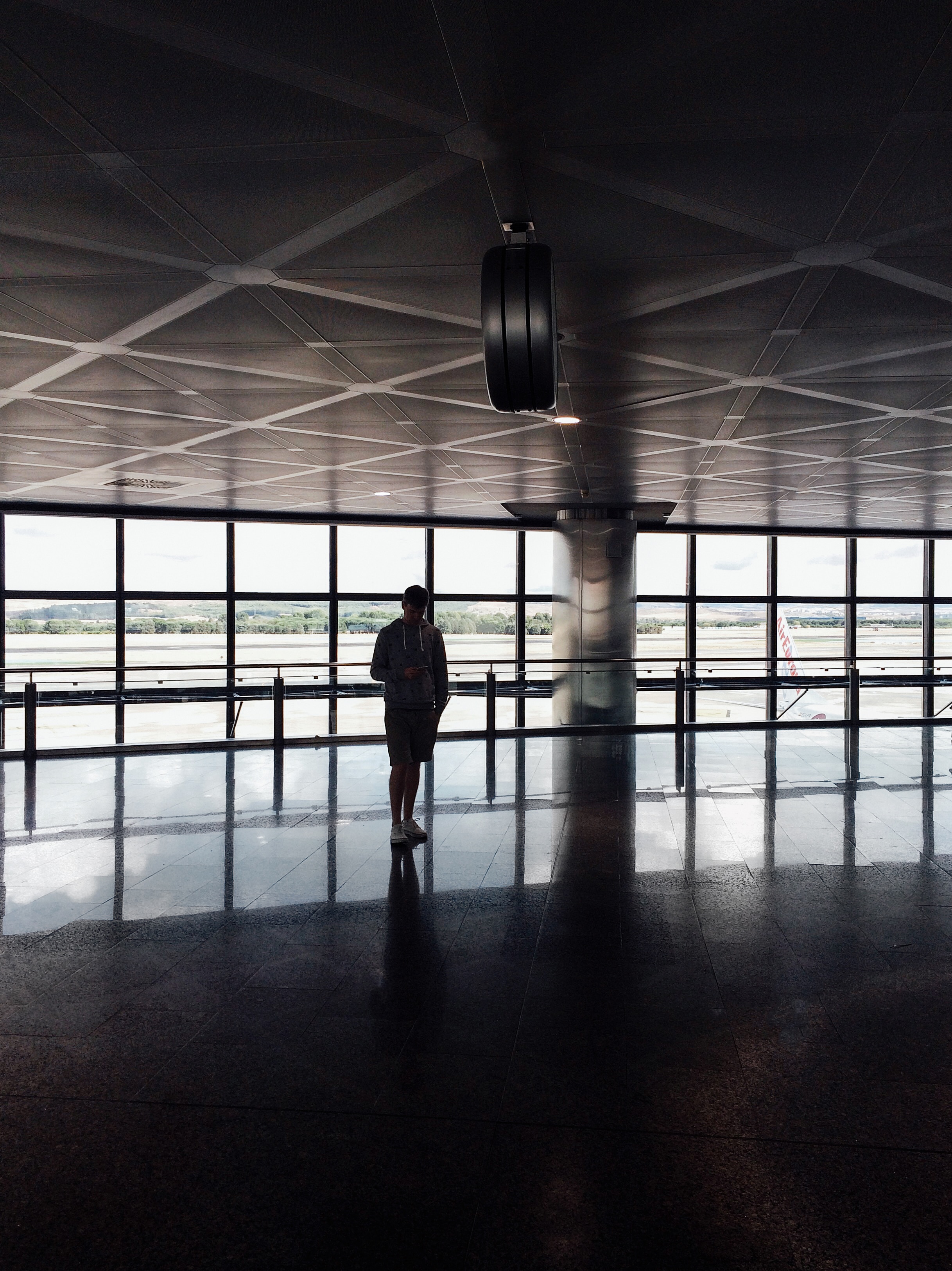 silhouette of man standing inside airport