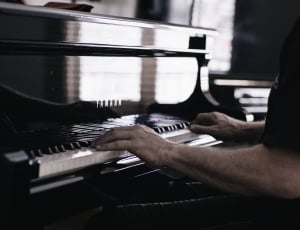 person playing black and white piano keyboard thumbnail