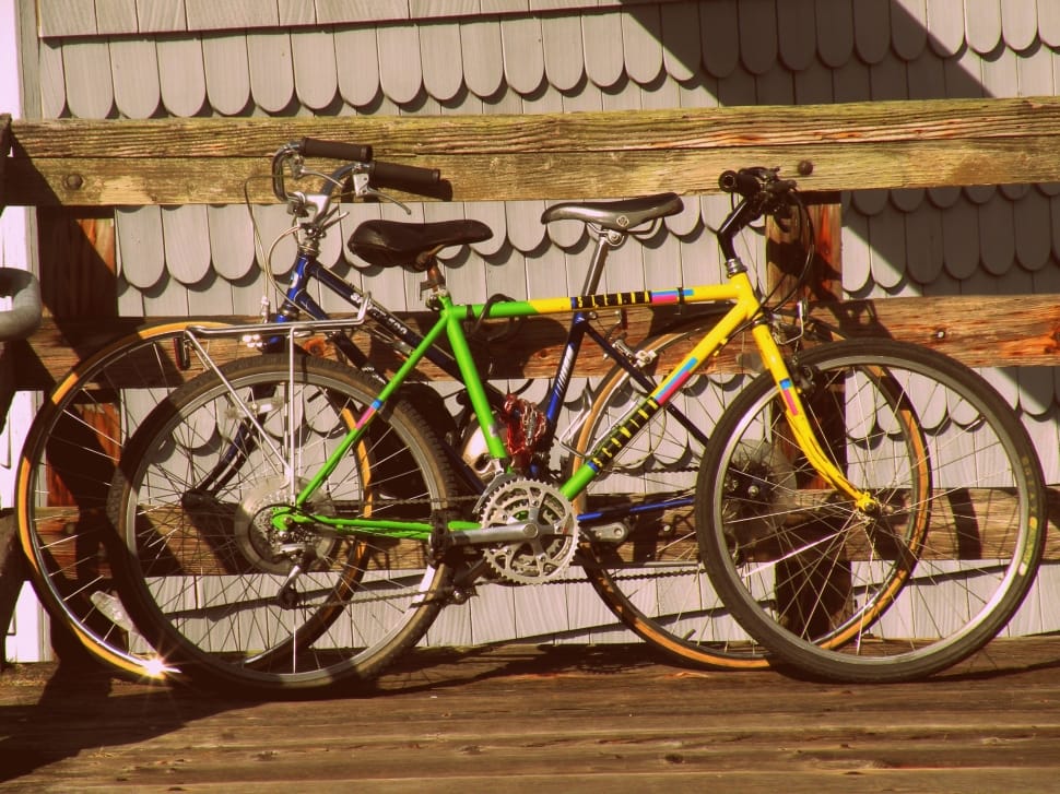 yellow and green cruiser bicycle on brown wooden fence preview
