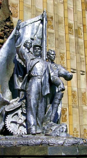 three men in behind of flag statue thumbnail
