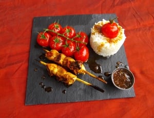 cooked meat on stick with tomatoes and rice meal thumbnail