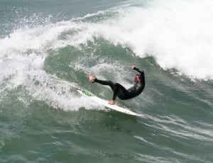 man in black wetsuit and white and green sufrboard thumbnail