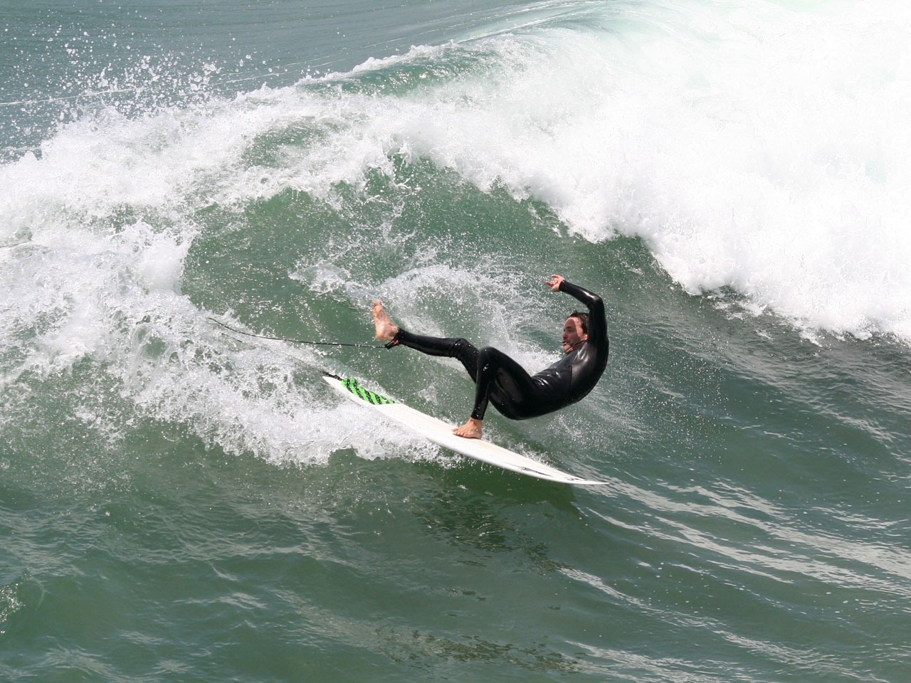 man in black wetsuit and white and green sufrboard