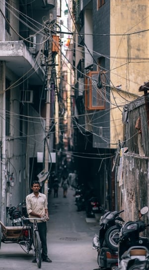 man with tricycle in urban alley thumbnail