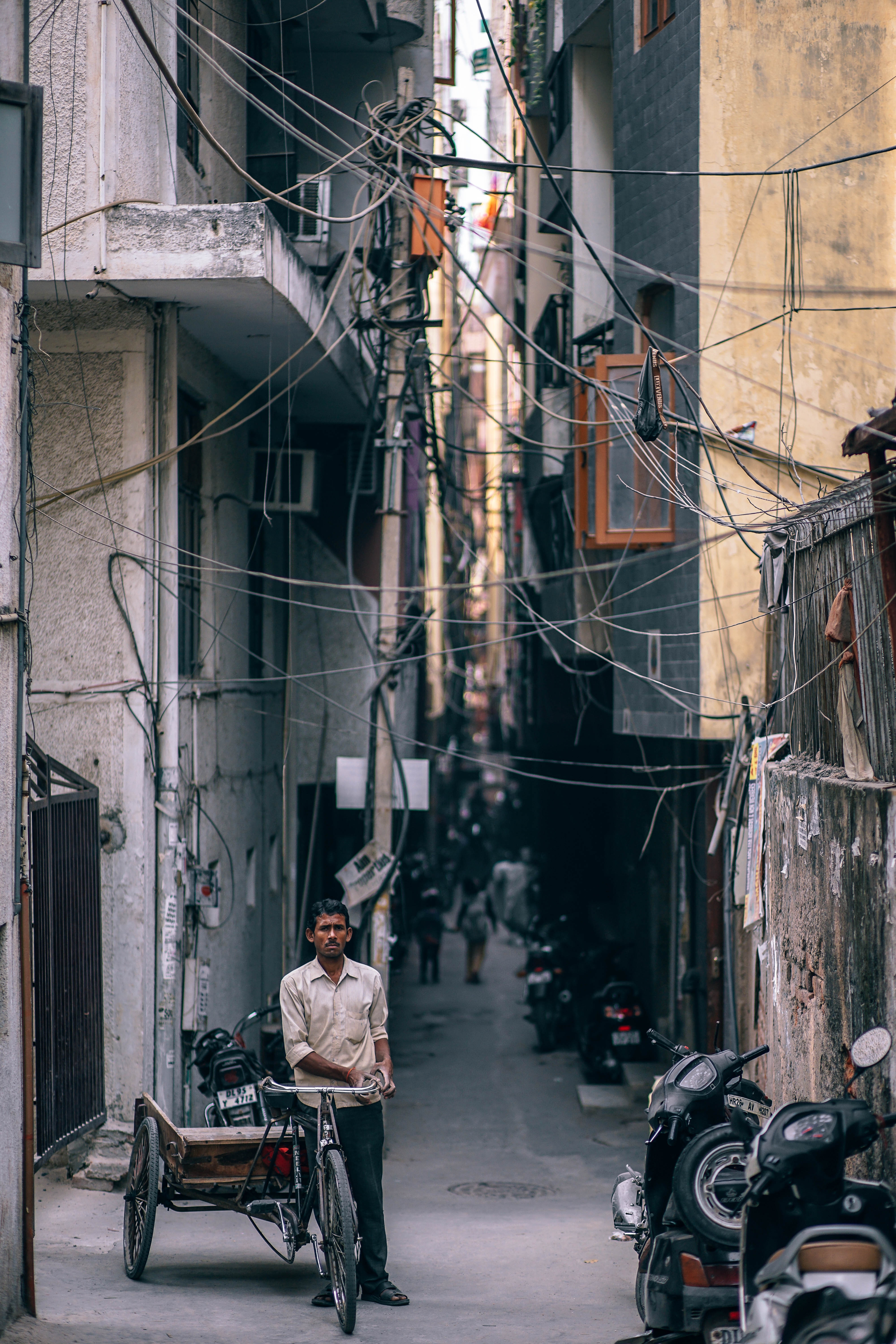 man with tricycle in urban alley