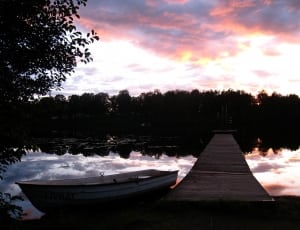 canoe boat on river dock during golden hour thumbnail