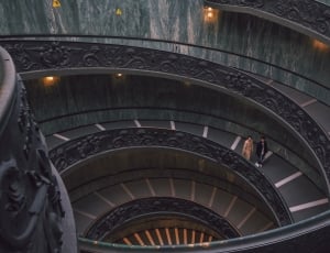 two men walking on spiral staircase thumbnail