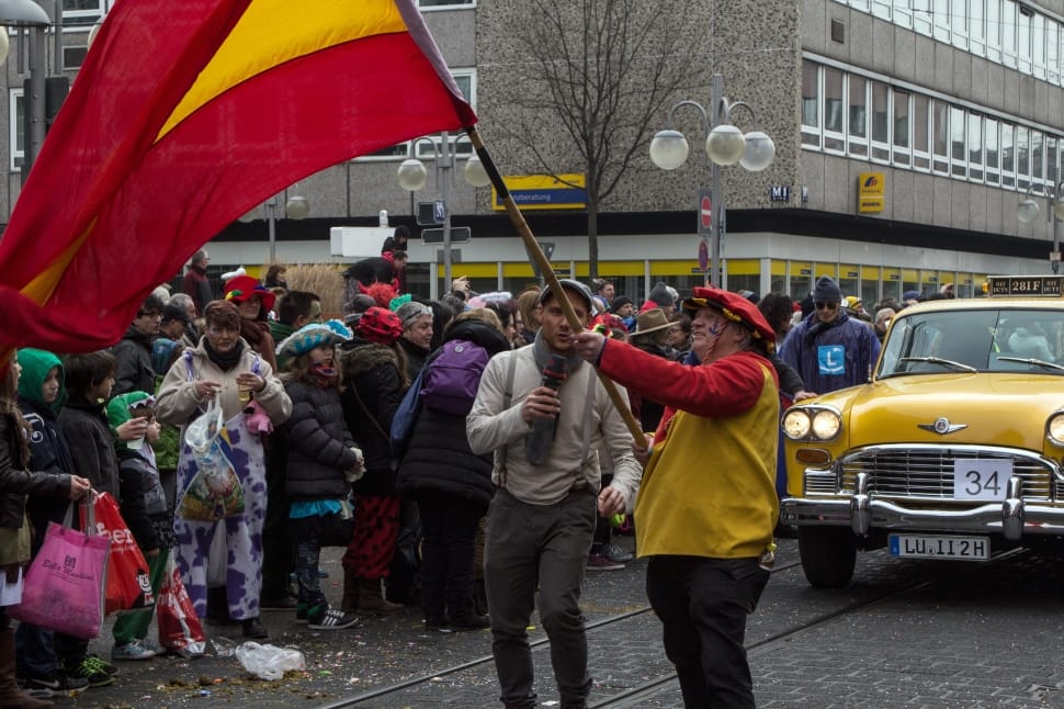 person waving flag on crowded street preview
