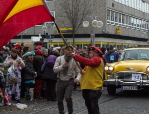 person waving flag on crowded street thumbnail
