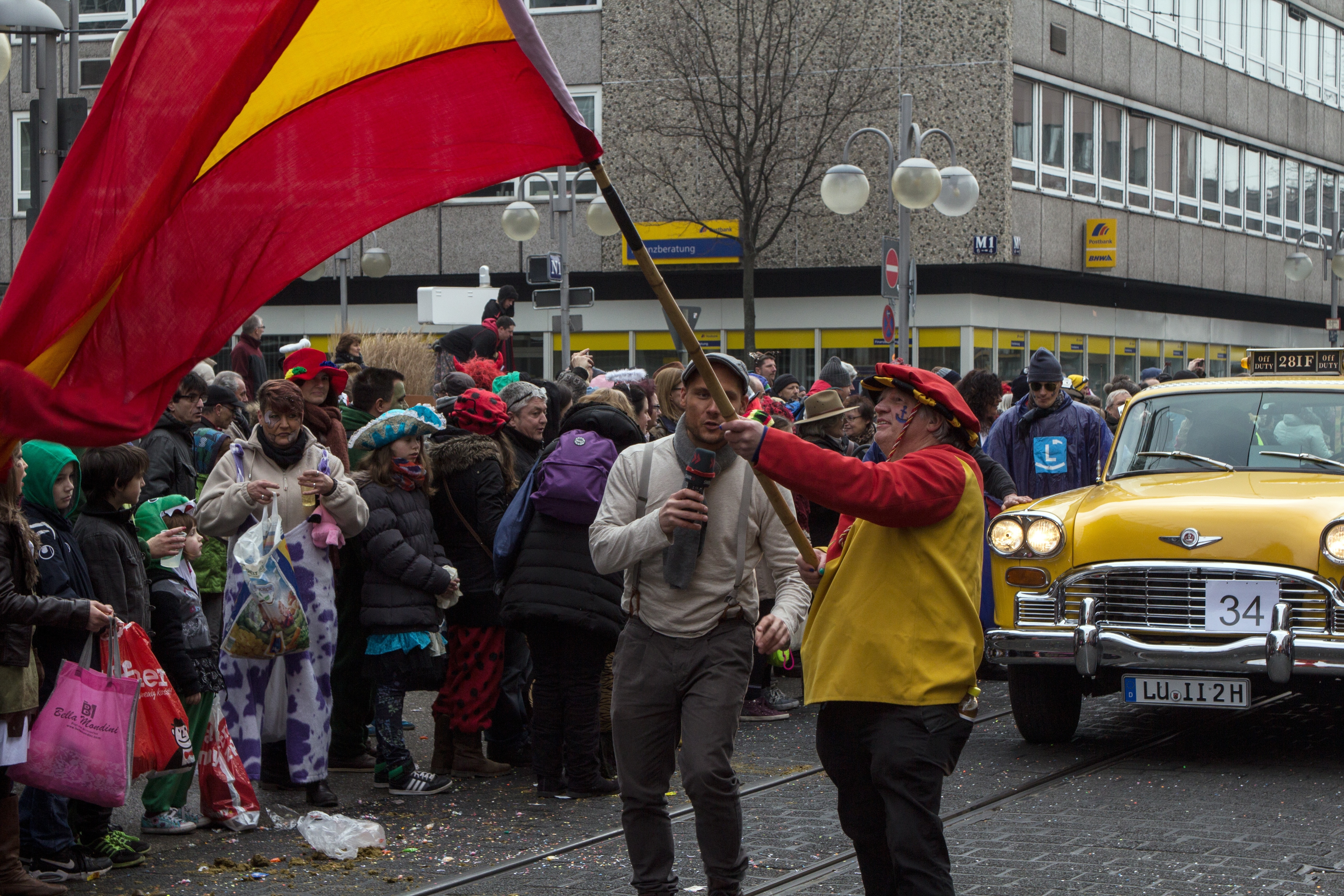 person waving flag on crowded street