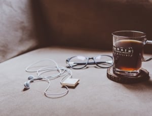 clear mug with coffee beside black frame eyeglasses thumbnail
