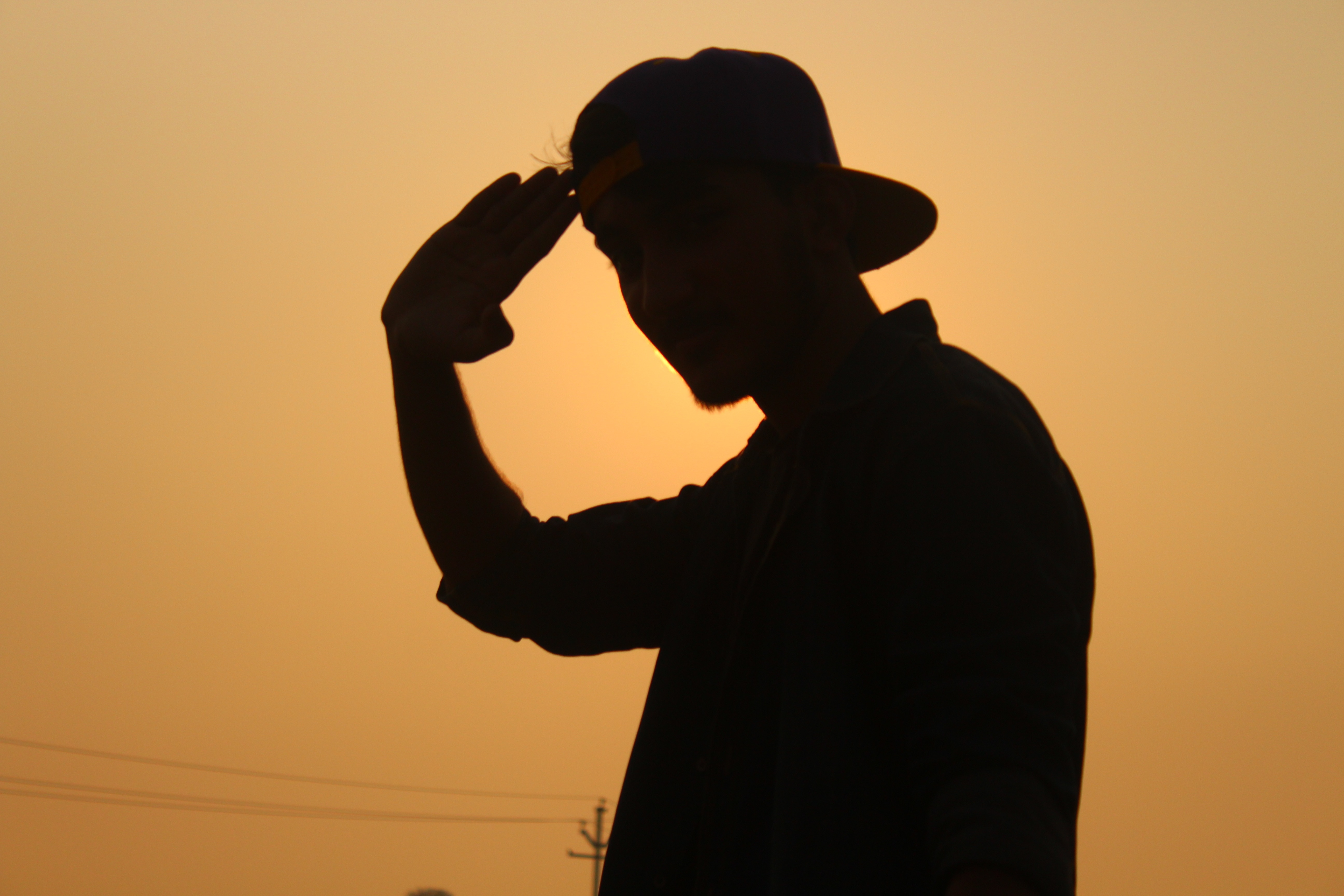 silhouette of man wearing fitted cap