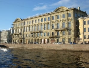 body of water near the building under blue sky during daytime thumbnail