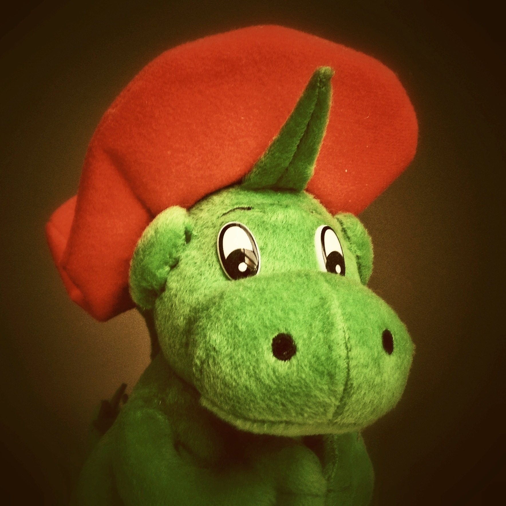 red and green dinosaur plush toy