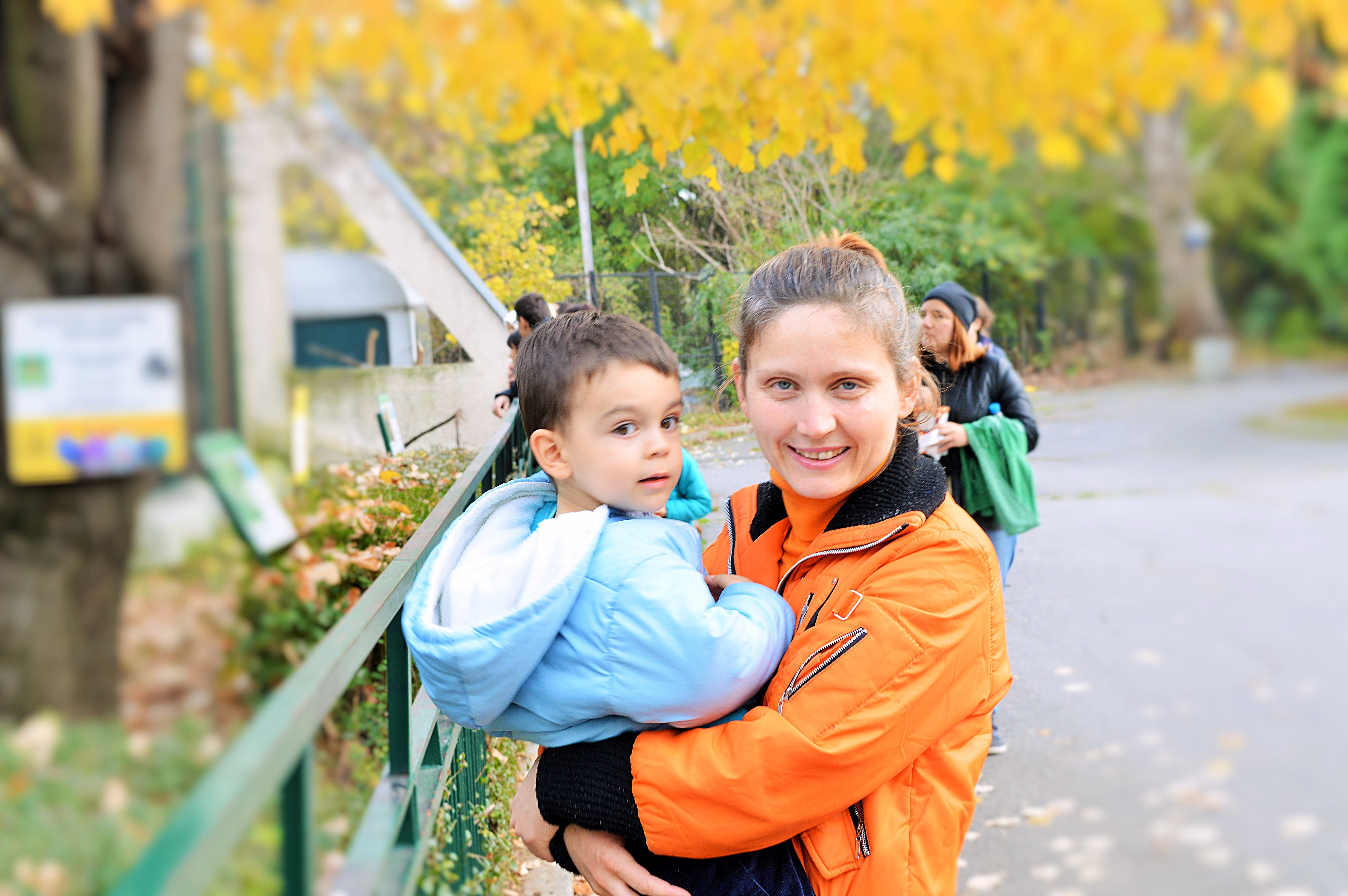 woman carrying his child in teal full zipped jacket