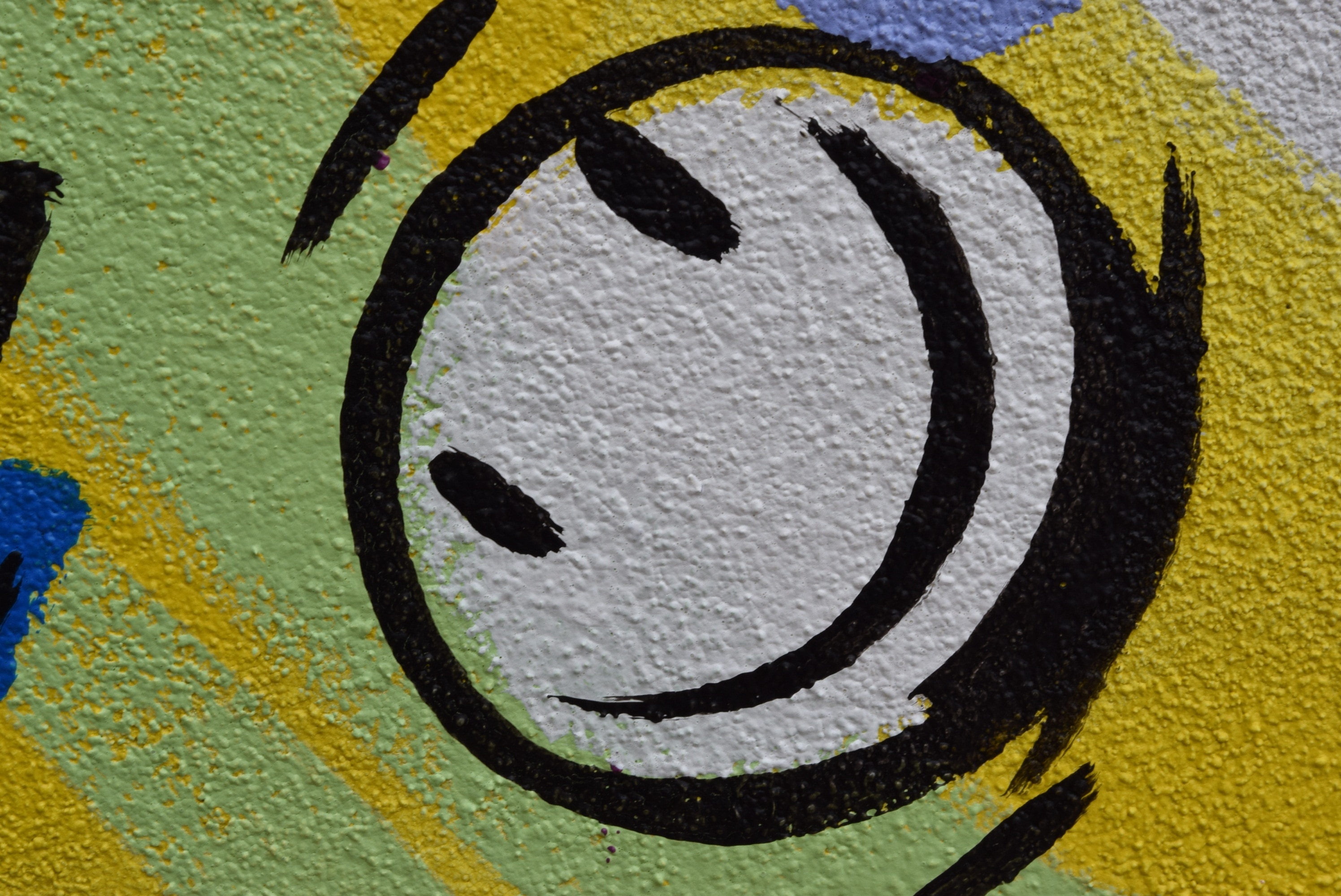 painting of black, yellow and white smiley emoji