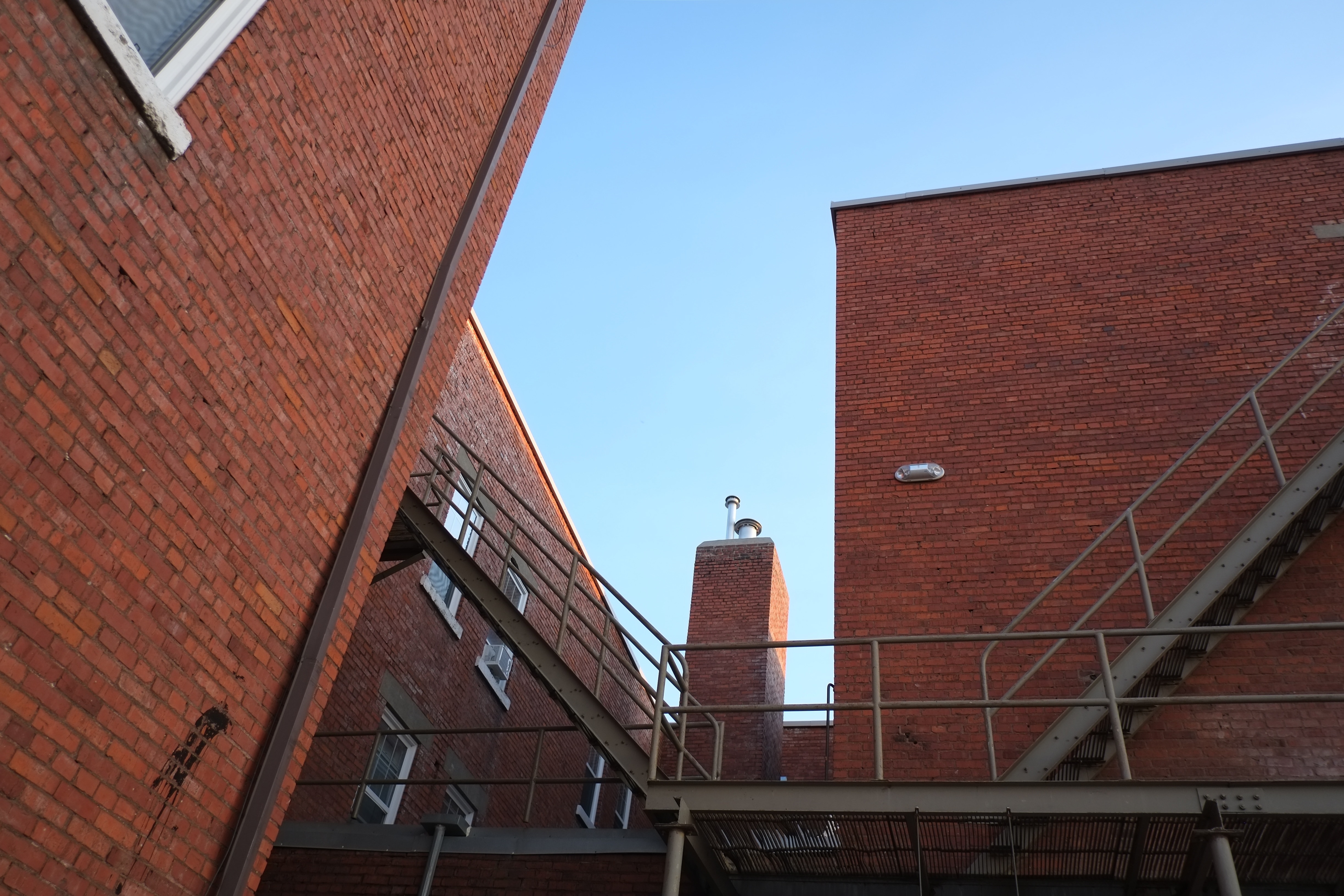 brown brick building with fire escape stairs