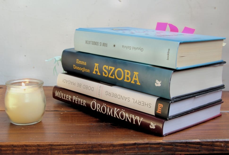 clear glass and white votive candle with 4 reading books preview