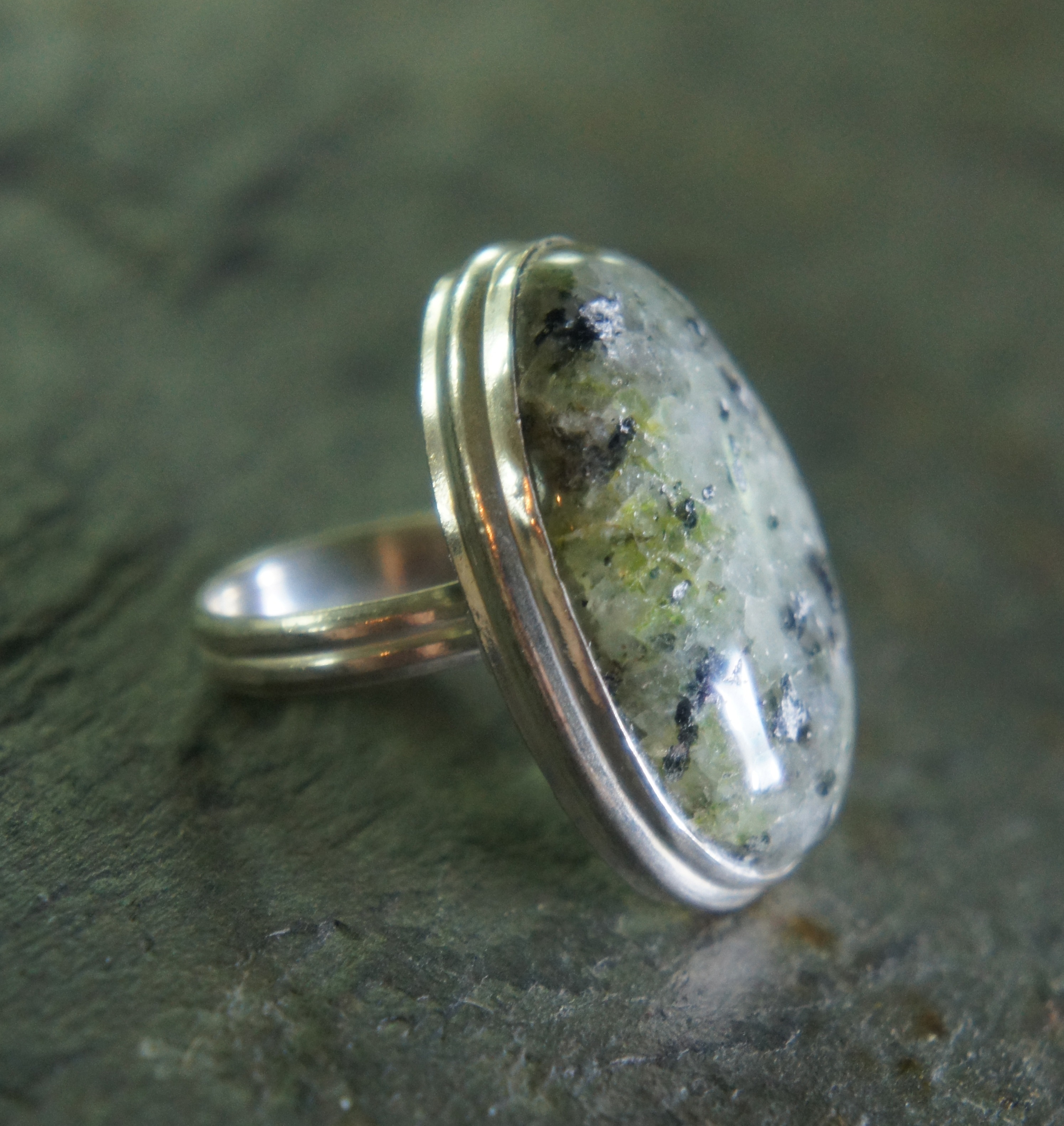 silver cabochon ring on gray marble surface
