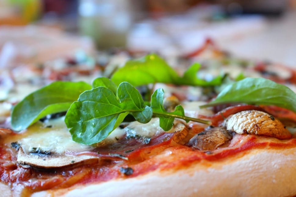 pizza with green leaves on top preview