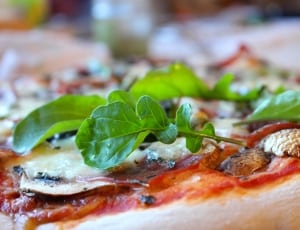 pizza with green leaves on top thumbnail