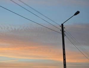 black post lamp with electric wires during sunset thumbnail