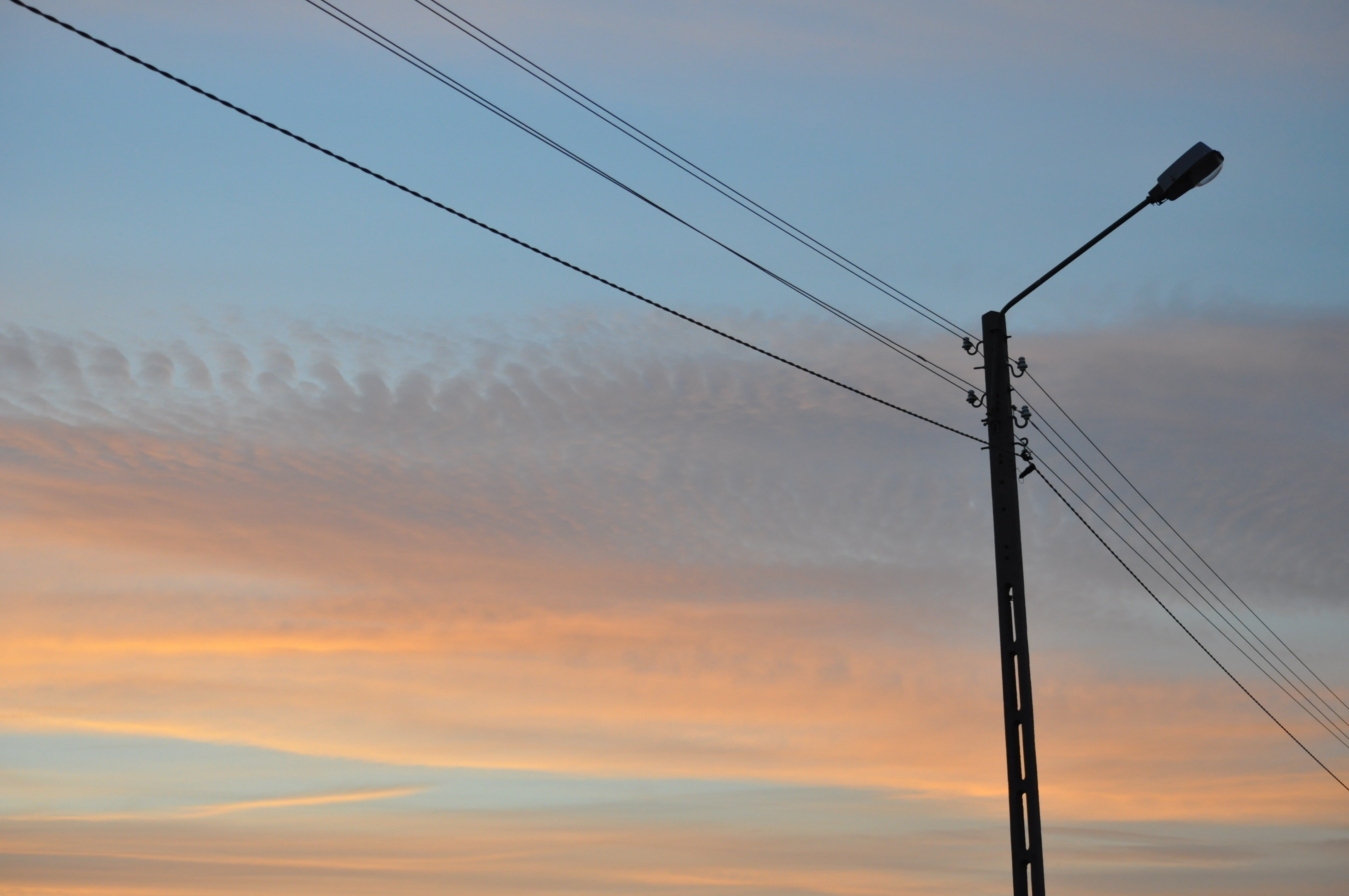black post lamp with electric wires during sunset