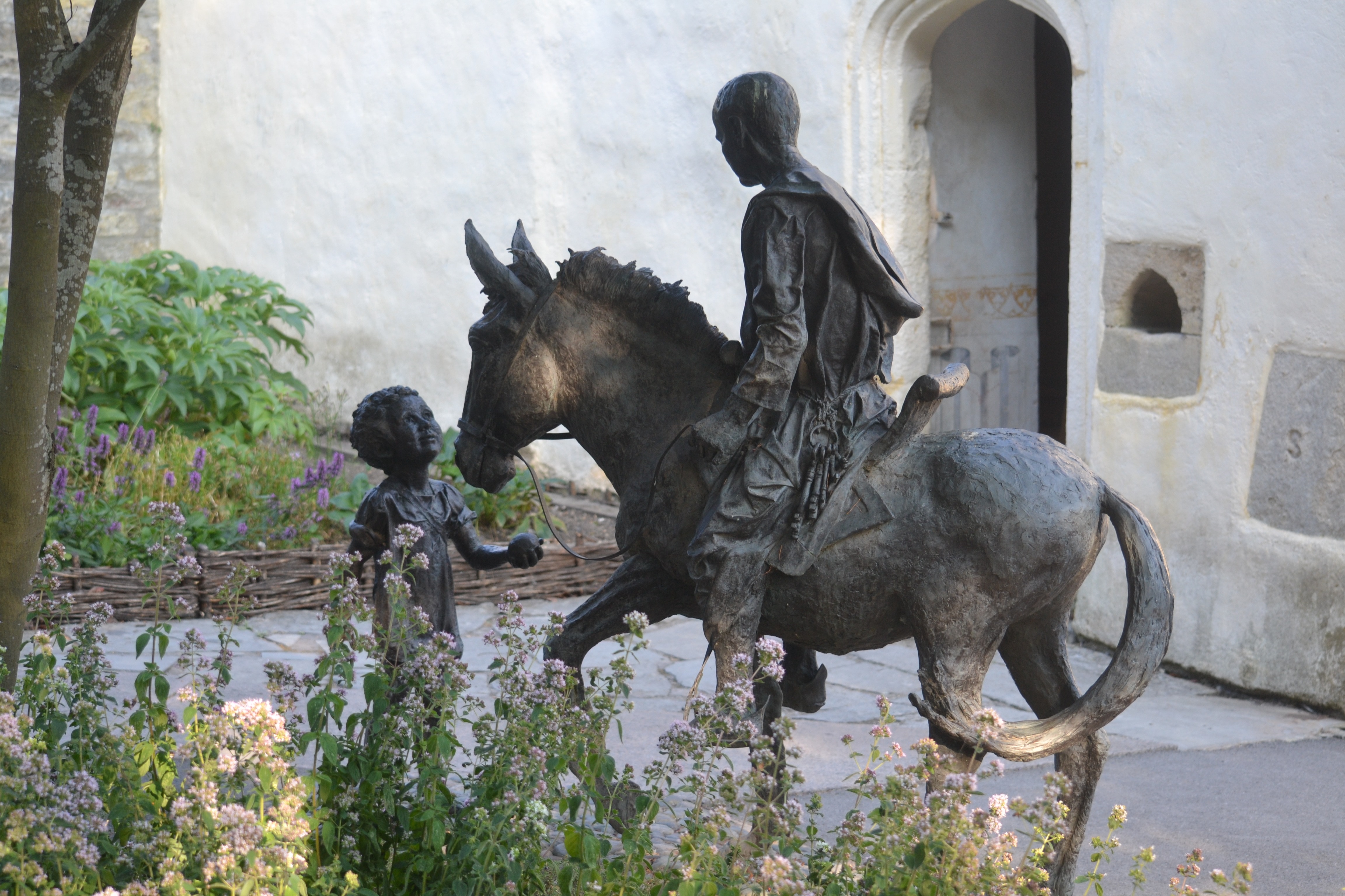 person riding horse infront of child monument