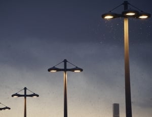 four lighted lampposts during night time thumbnail