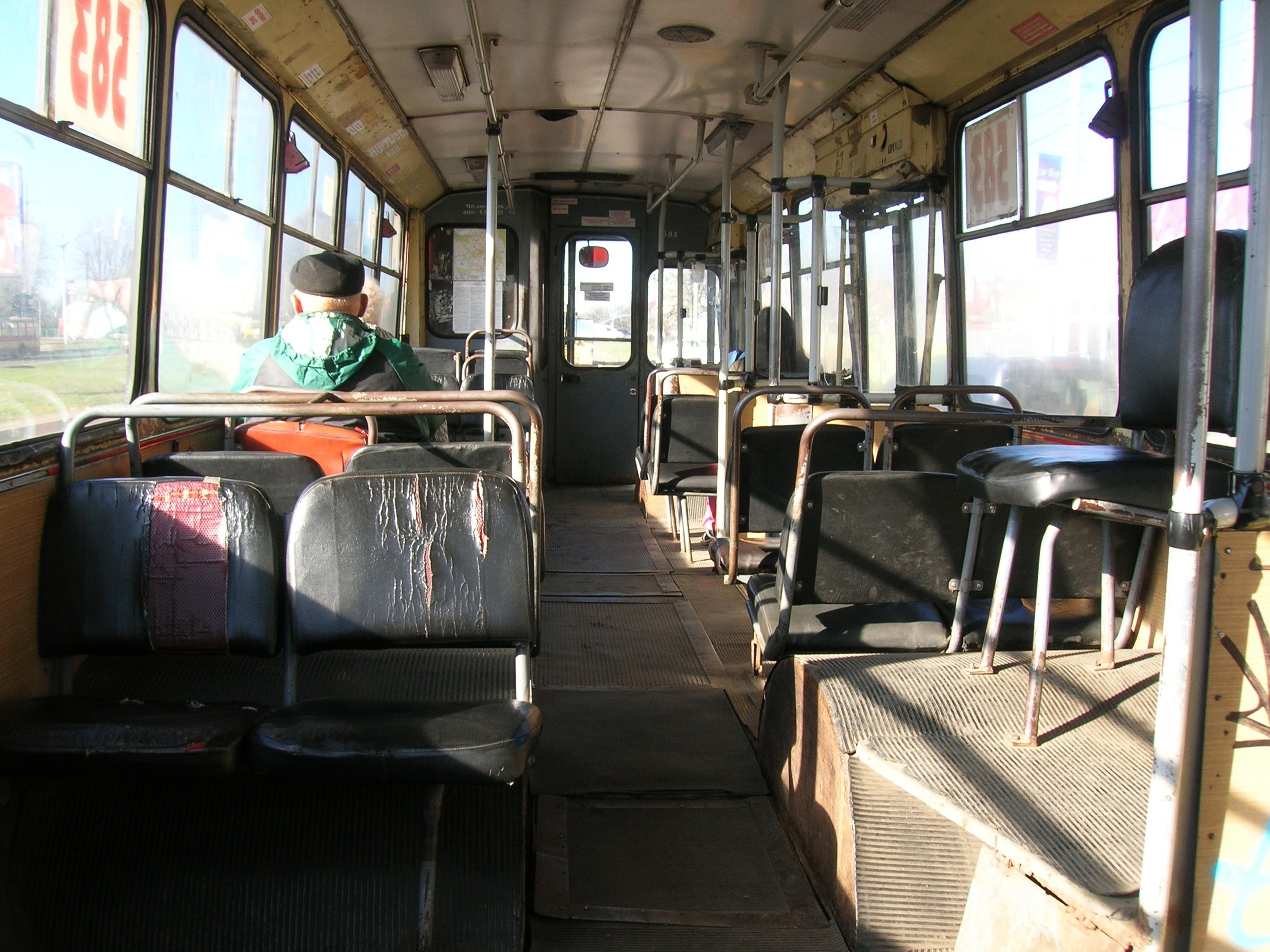 men wearing green coat inside the bus during daytime