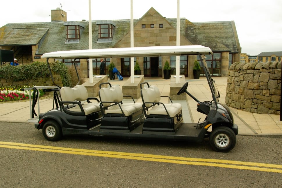 black golf cart with 6 seater parked near building preview