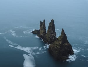 gray mountain surrounded by body of water thumbnail