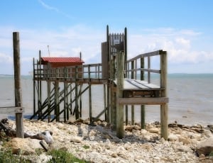 brown wooden dock with house during daytime thumbnail