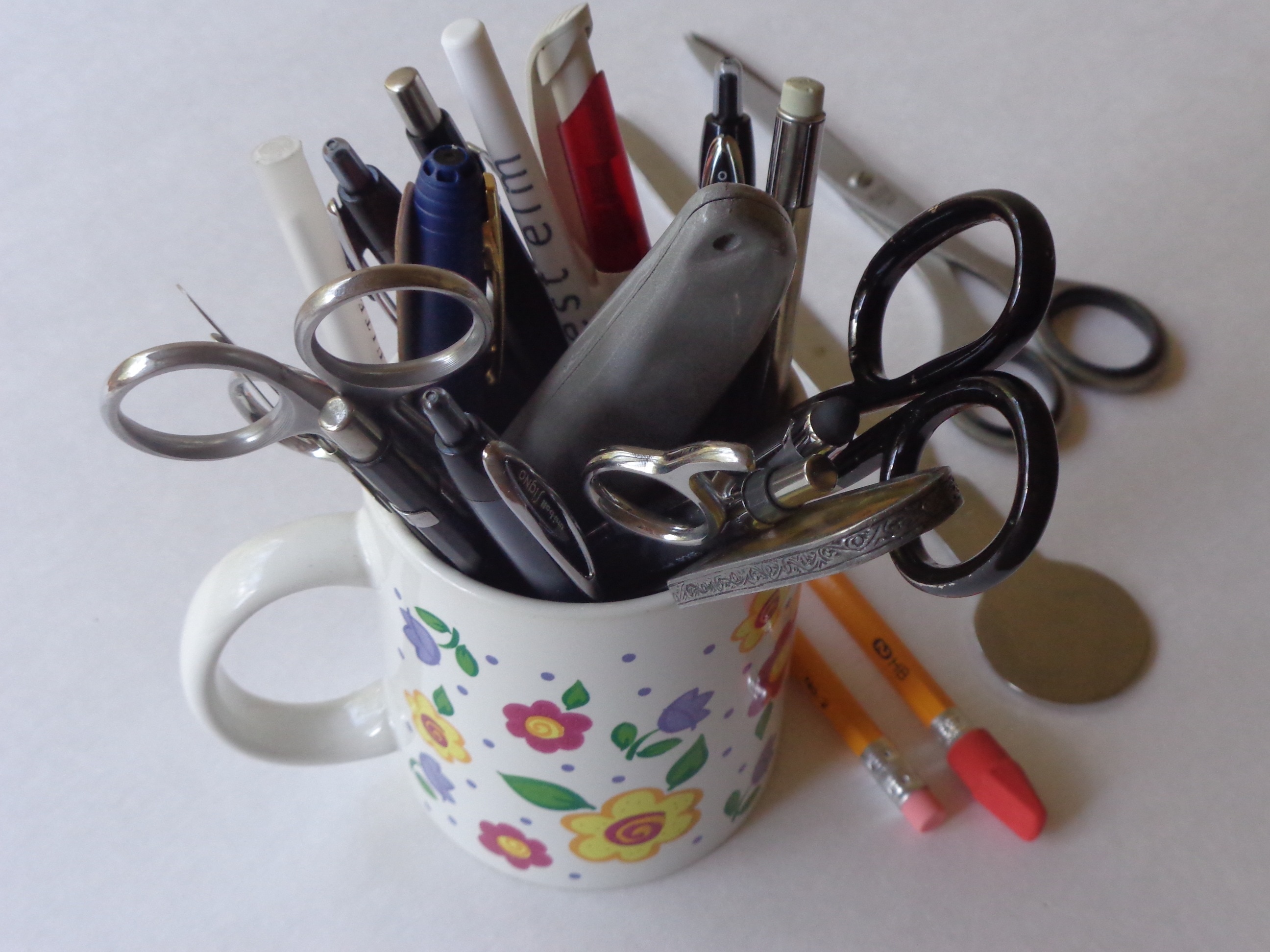 scissors, pens and pencils on ceramic mug