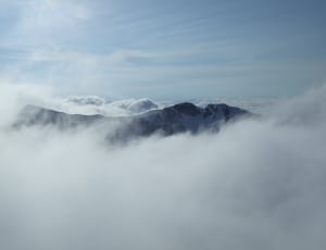 photography of mountain top covered with clouds during daytime thumbnail