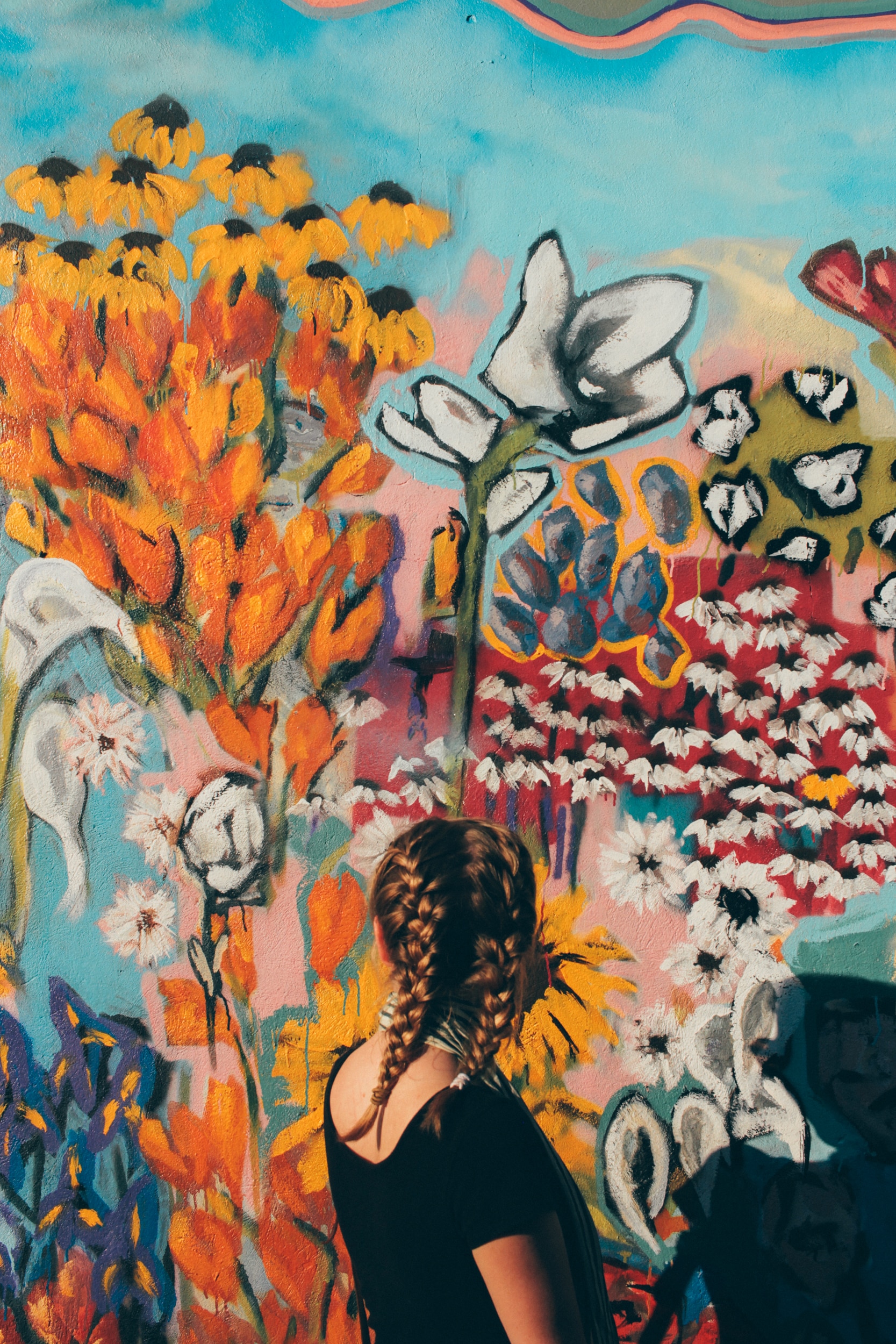 woman looking at a floral wall artwork