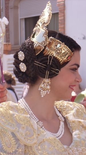 women's wearing gold crown and white necklace during day time thumbnail