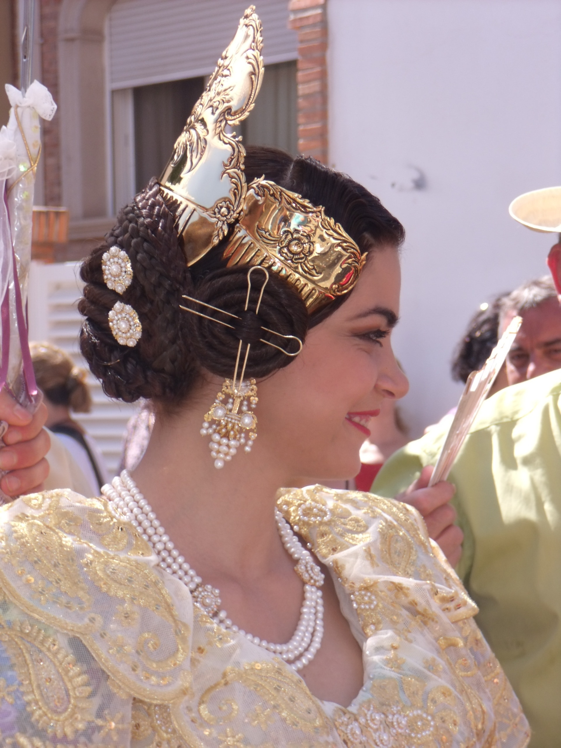 women's wearing gold crown and white necklace during day time