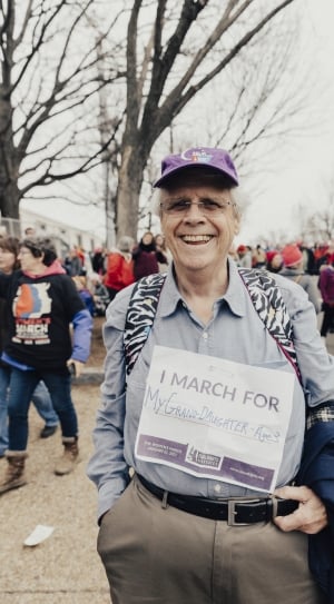 man in gray dress shirt holding i march for print signage thumbnail