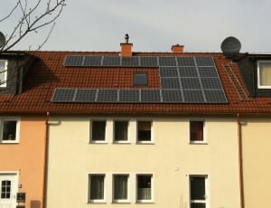 white and brown house with black panel solar thumbnail