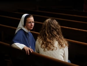 woman in white long sleeve shirt talking to a nun thumbnail