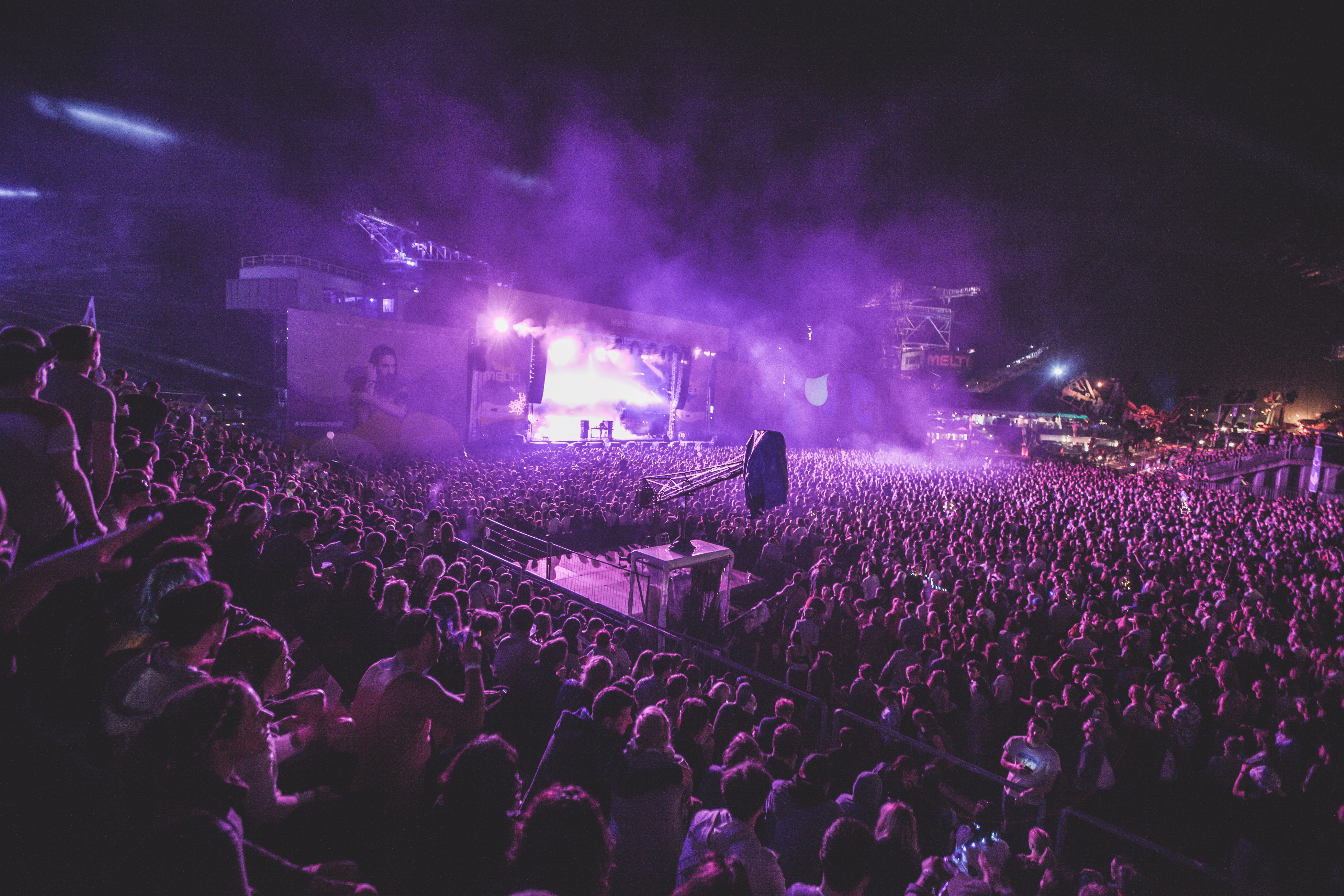 group of people in a concert with smoke and purple light