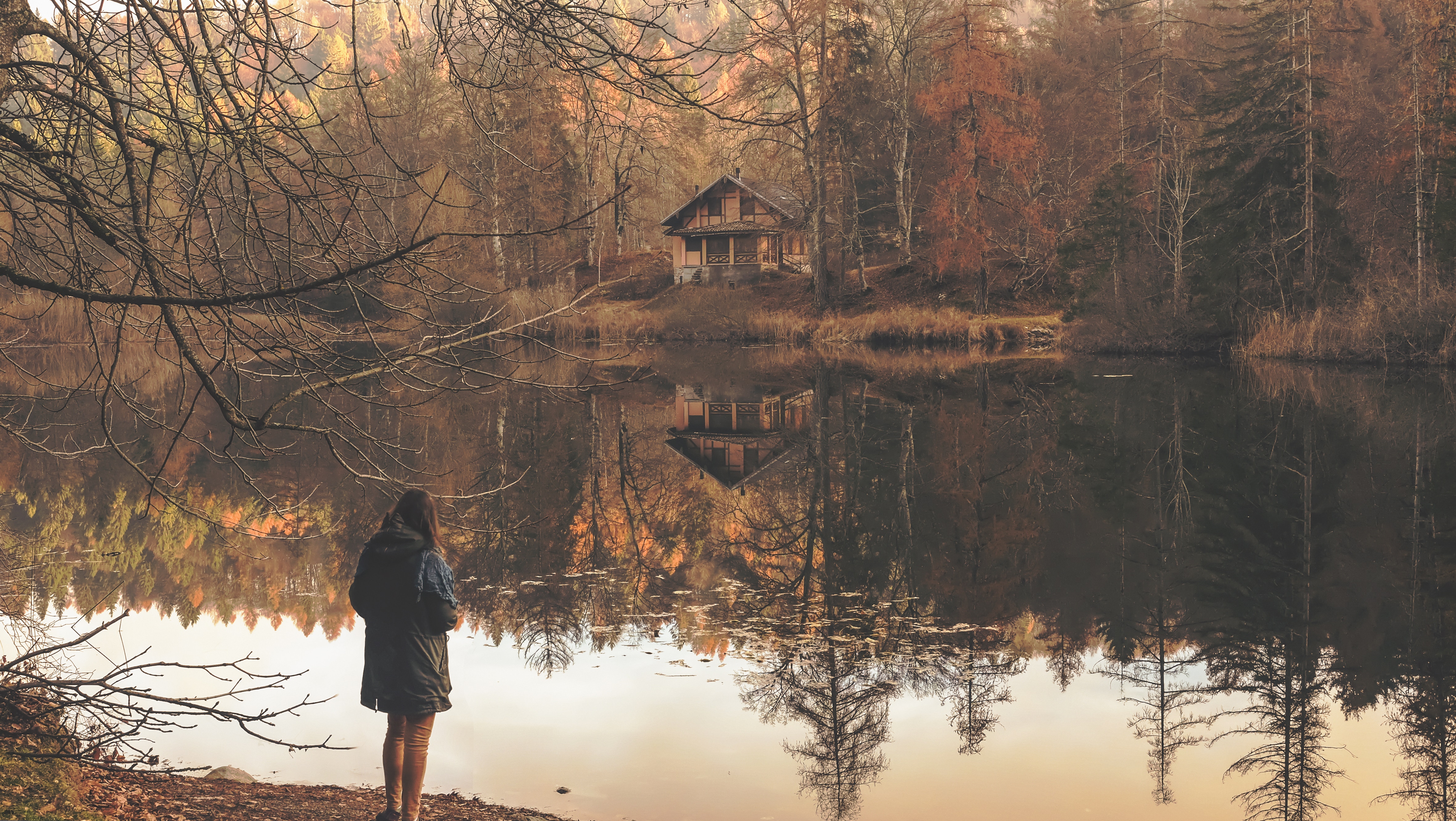 woman in black jacket in front of lake during day time