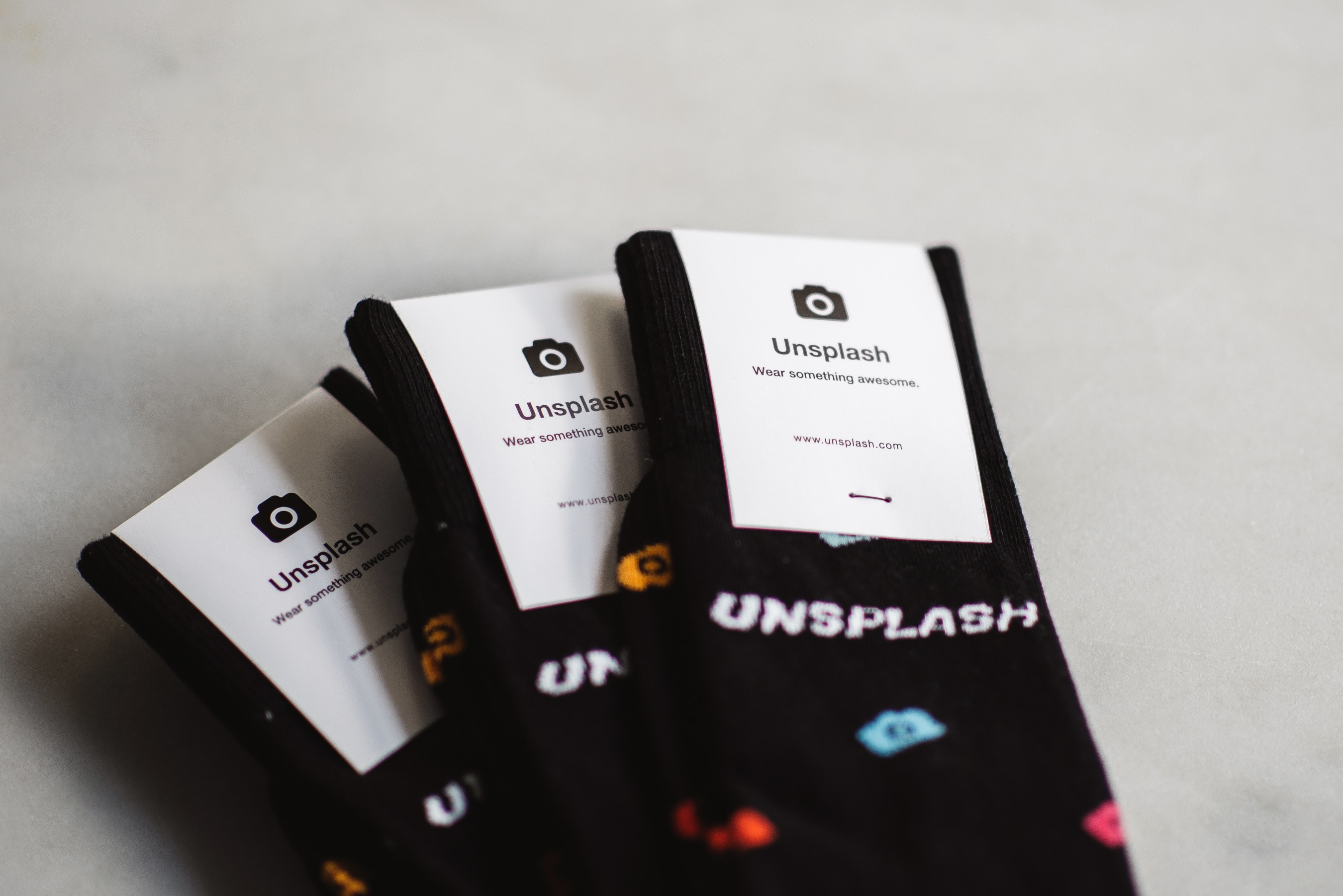 three paired of black  unplash socks