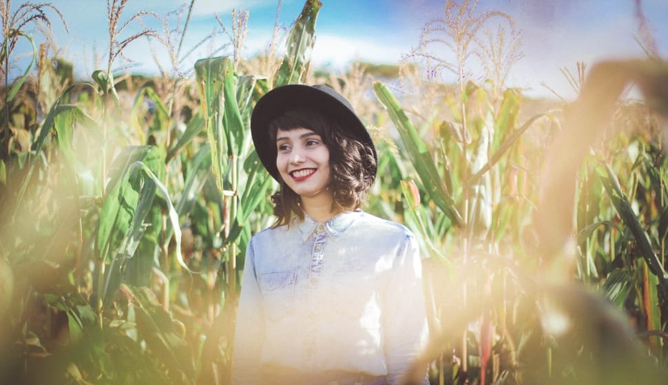 woman wearing white collared long sleeve shirt in green corn plants preview