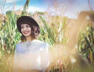 woman wearing white collared long sleeve shirt in green corn plants thumbnail