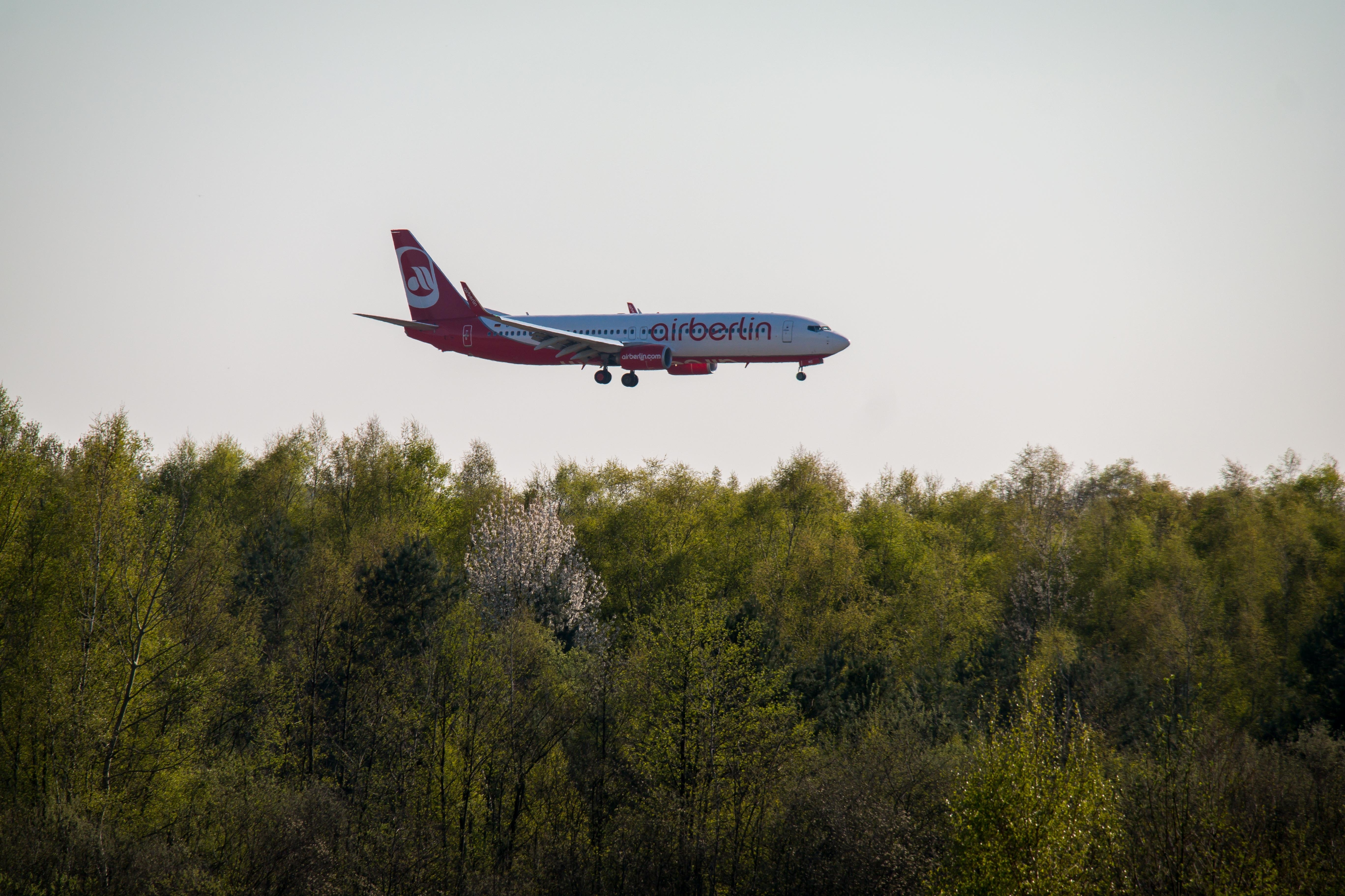 red and white Airberlin plane flying during daytime