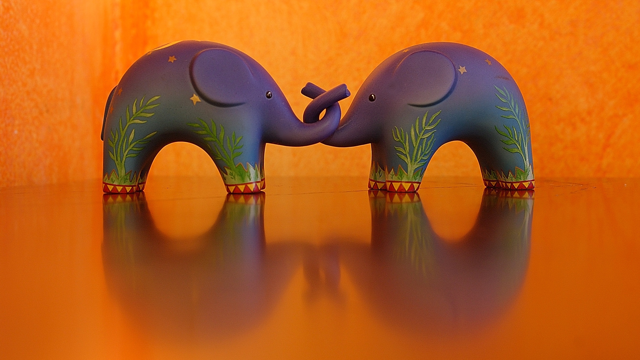2 purple and green elephant figurines
