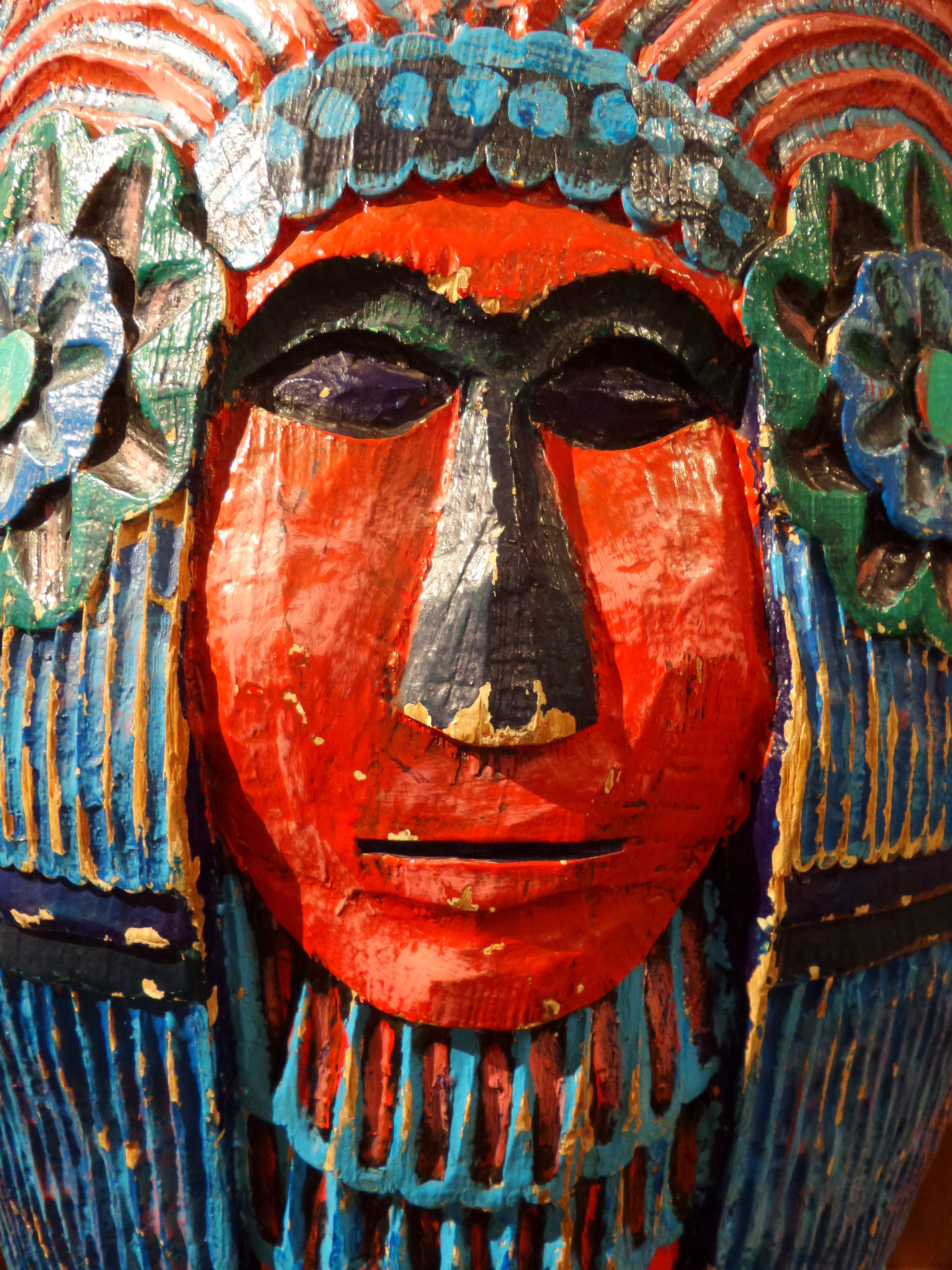 red blue and black wooden carved mask